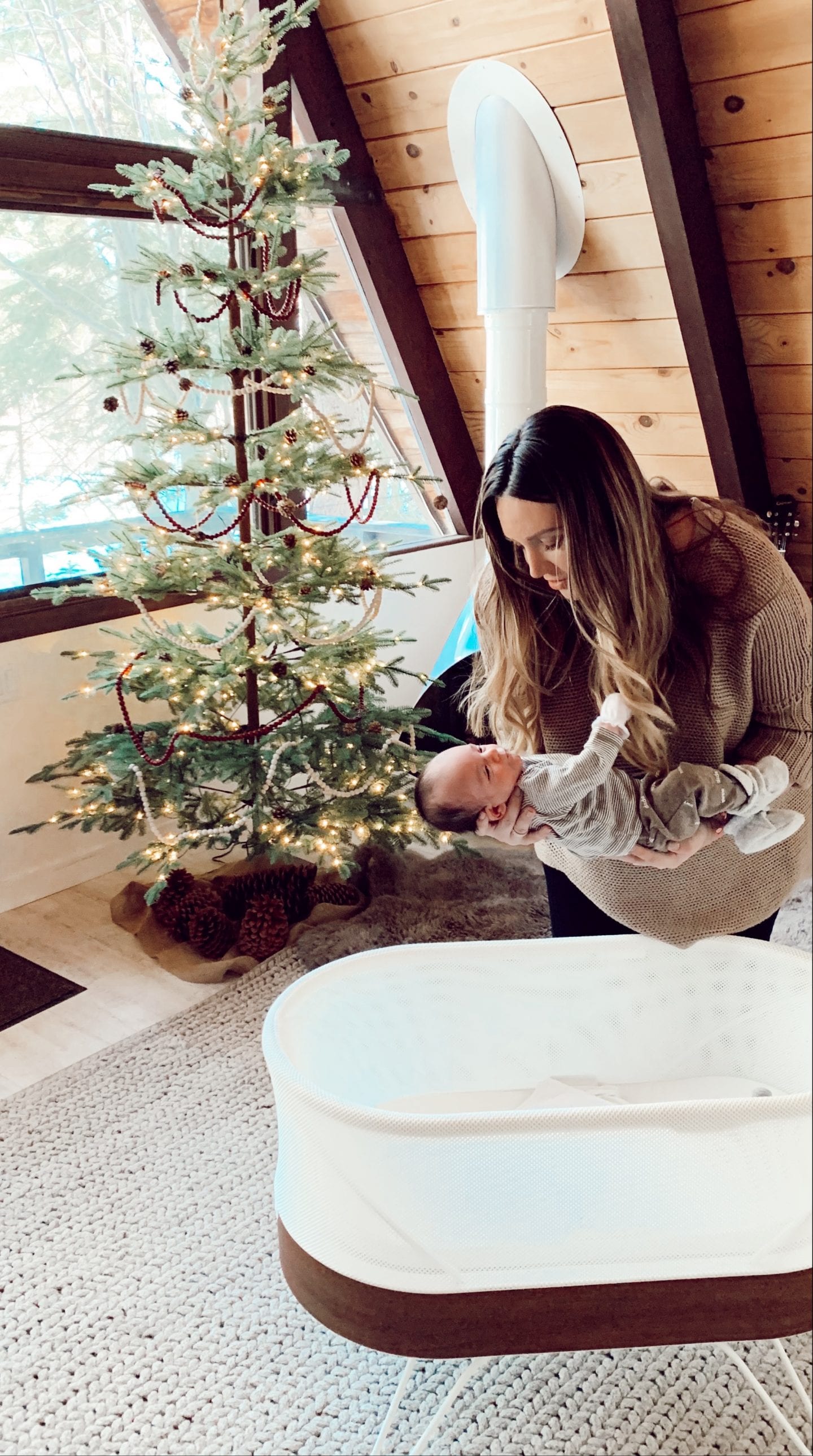 snoo review | Baby Snoo Bassinet Review by popular San Francisco life and style blog, Just Add Glam: image of a mom putting her baby in a Snoo Bassinet. 