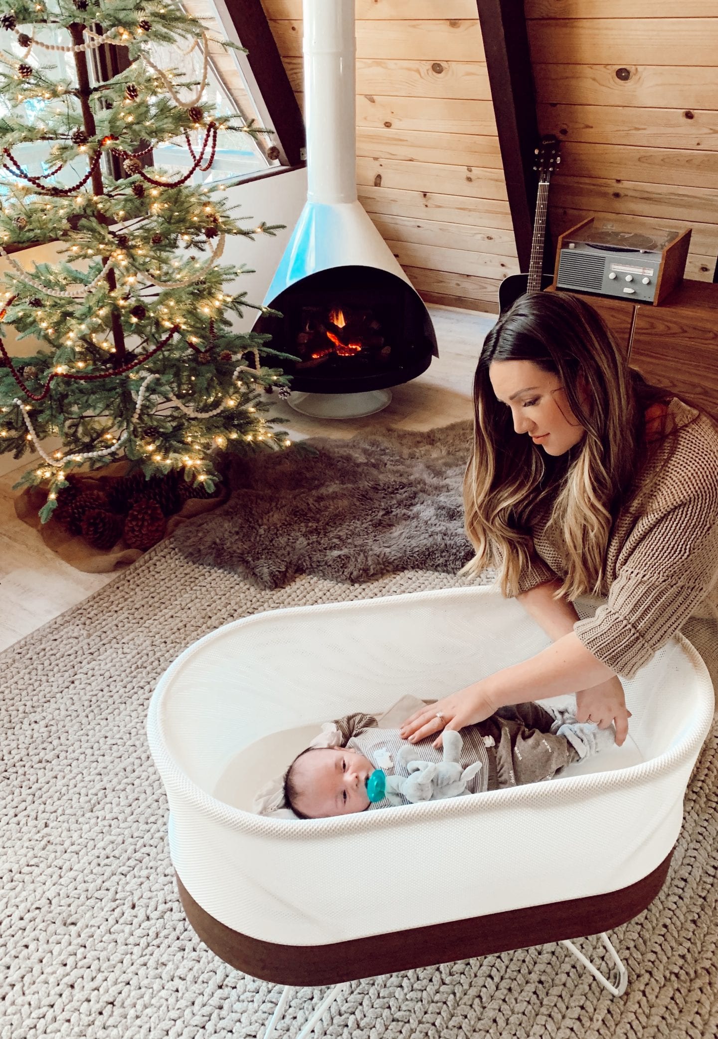 snoo review | Baby Snoo Bassinet Review by popular San Francisco life and style blog, Just Add Glam: image of a woman looking at her baby in a Snoo bassinet. 