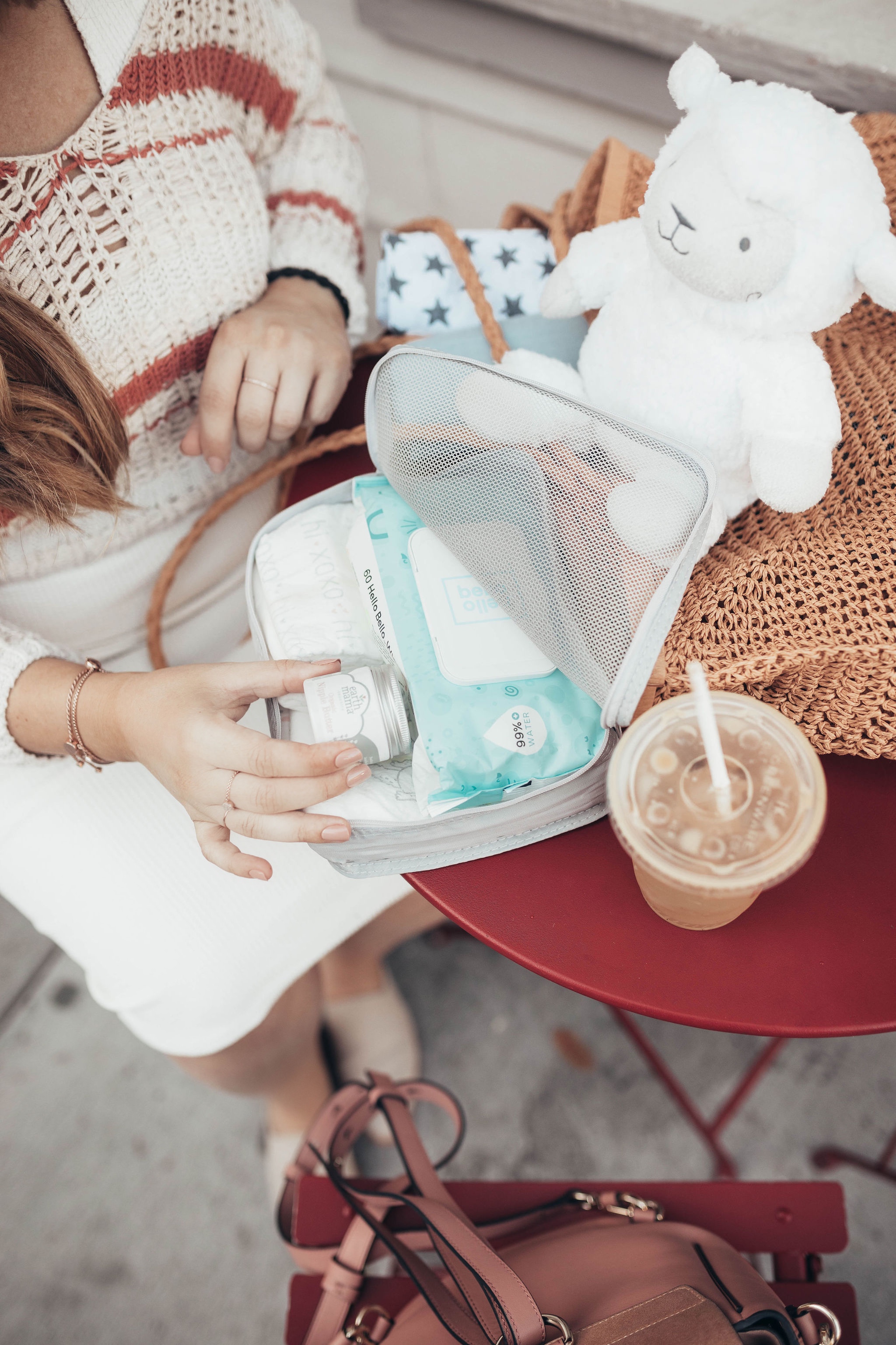 25 Bestseller Walmart Baby Products by popular San Francisco life and style blog, Just Add Glam: image of a woman sitting at a cafe table outside with an iced coffee, Walmart Mustela newborn arrival gift set, and other various Walmart baby products.