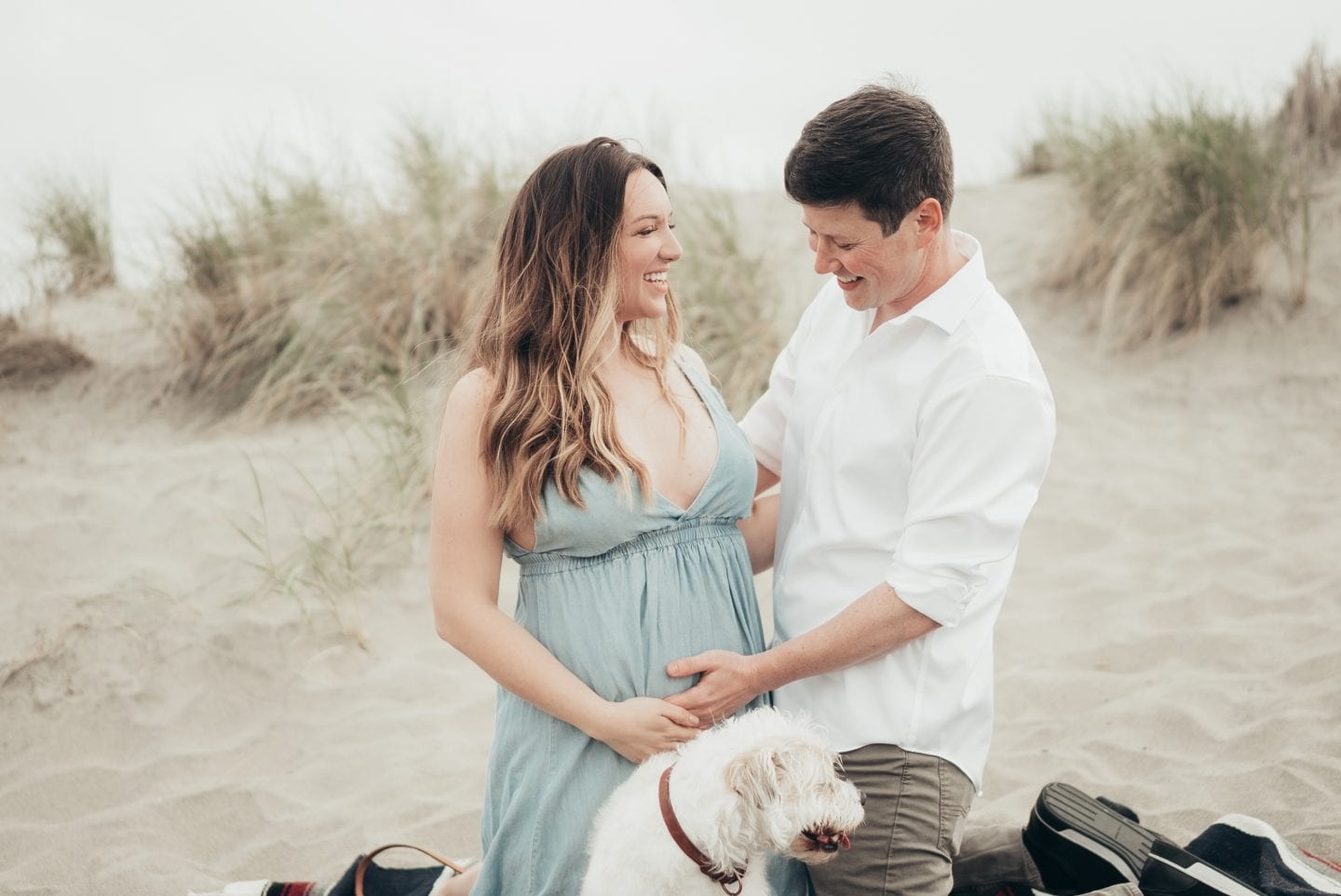 Maternity Style for Each Trimester by popular California fashion blog, Just Add Glam: image of a husband and wife doing a maternity shoot on a beach.
