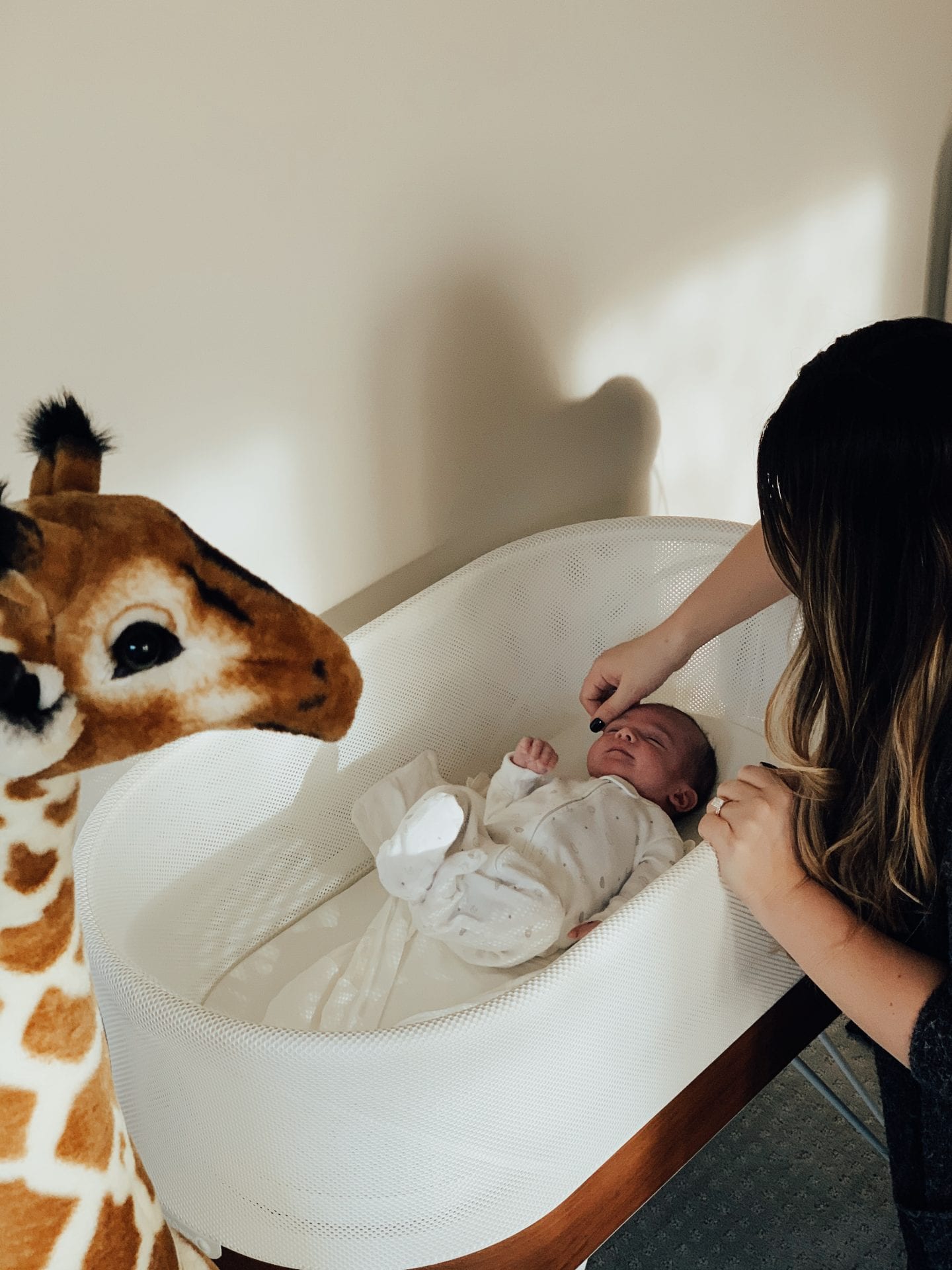 Baby Snoo Bassinet Review by popular San Francisco life and style blog, Just Add Glam: image of a woman looking at her baby in a Snoo Bassinet. 