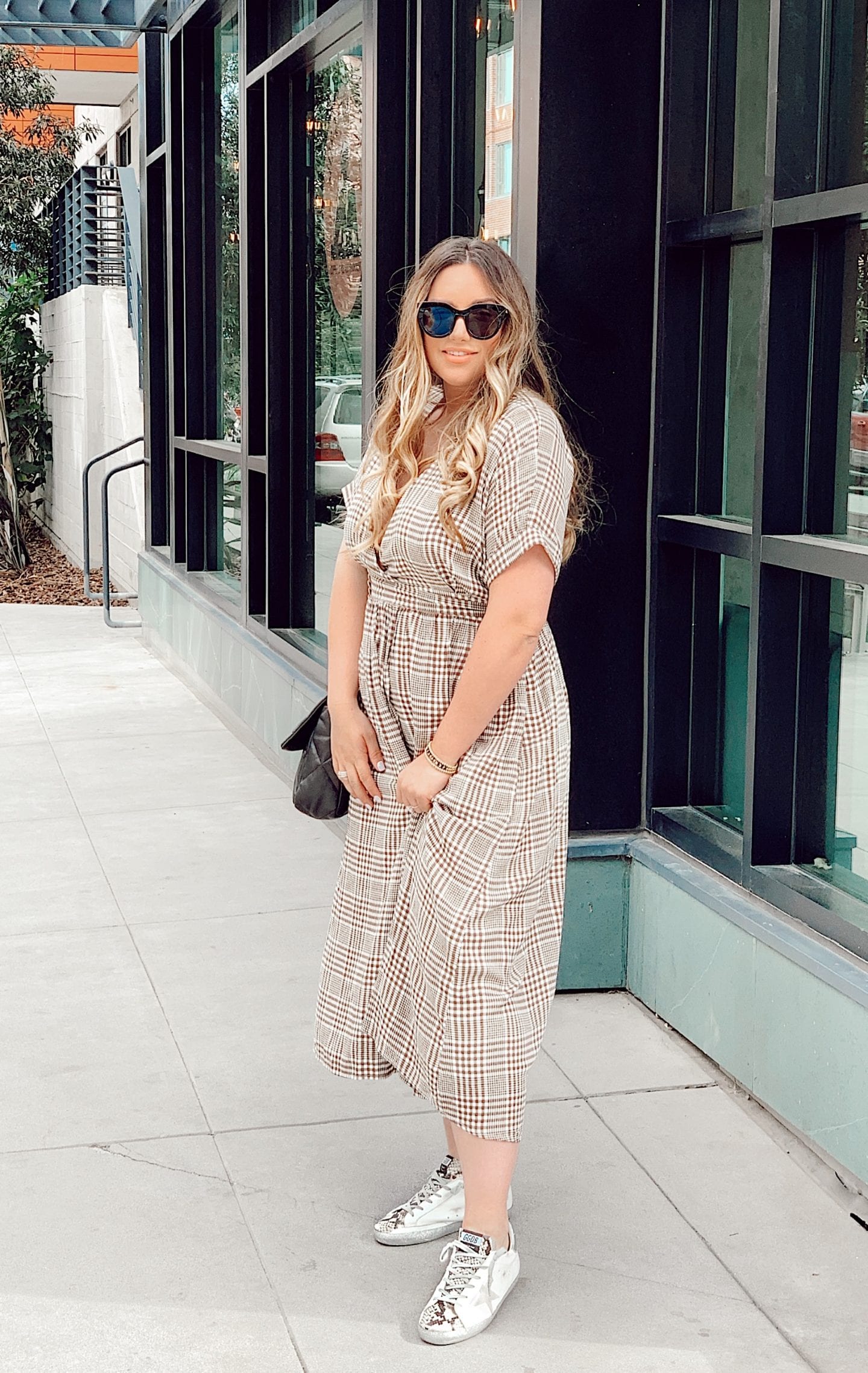 afterpay | How to Use Afterpay by popular San Francisco lifestyle blog, Just Add Glam: image of a woman wearing Sunglasses, Golden Goose Sneakers, and a Urban Outfitters UO Gabrielle Woven Midi Wrap Dress.
