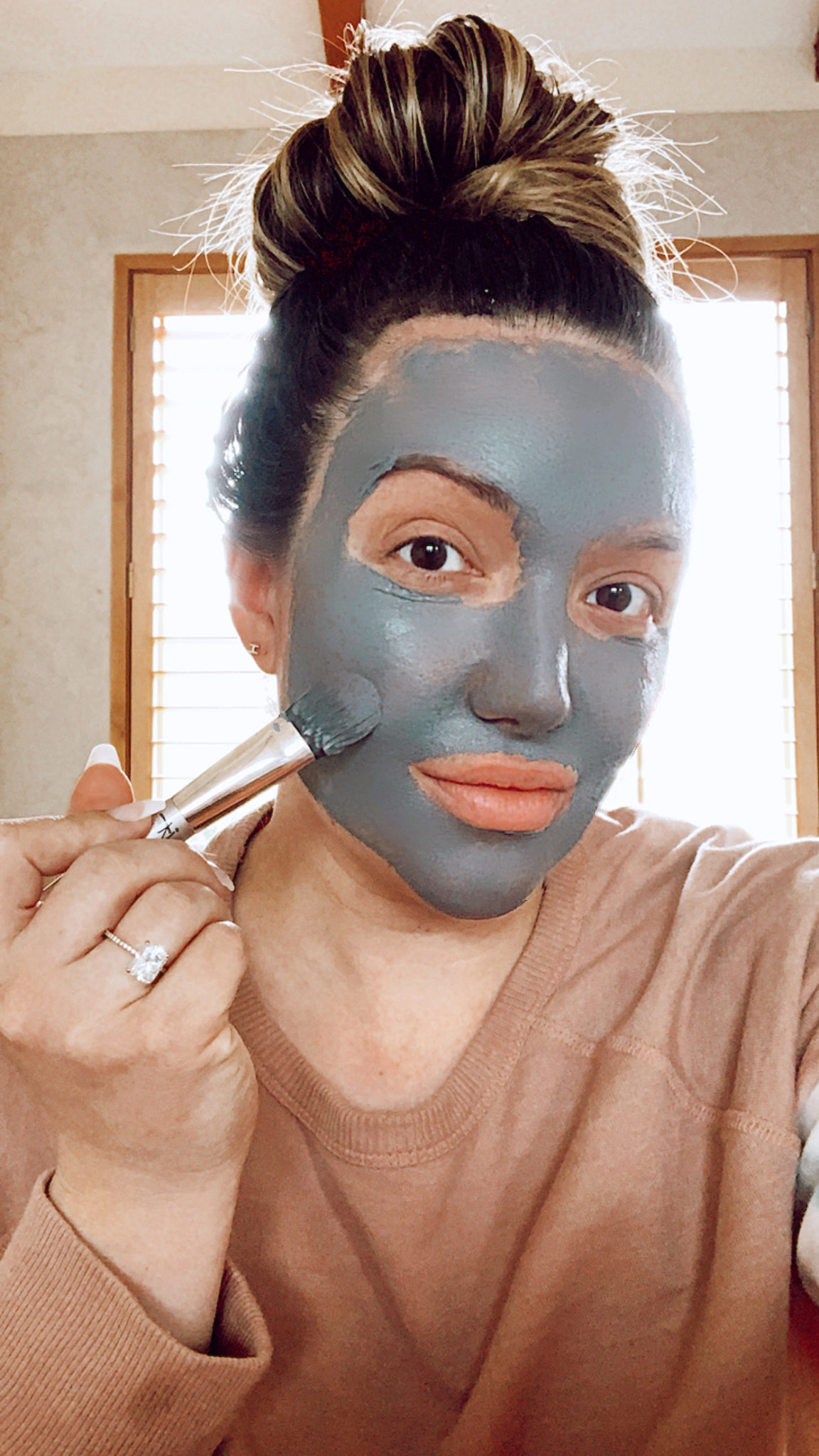charcoal face mask | Charcoal Masks by popular San Francisco beauty blog: image of a woman applying a charcoal mask. 