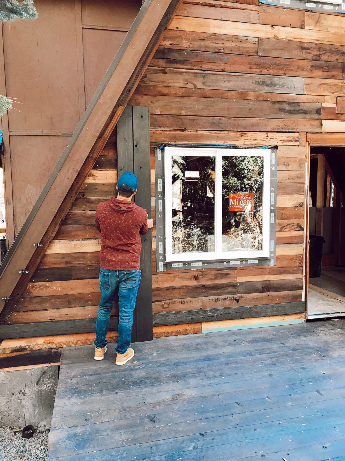 milgard windows | Milgard Windows by popular San Francisco life and style blog, Just Add Glam: image of a man installing some Milgard windows in a A-Frame cabin. 